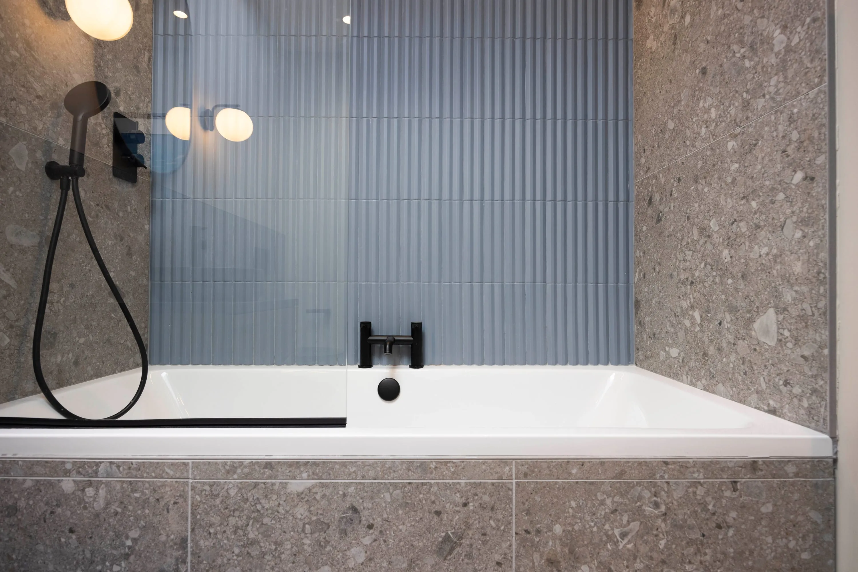 Bath with black fittings and terrazzo surround