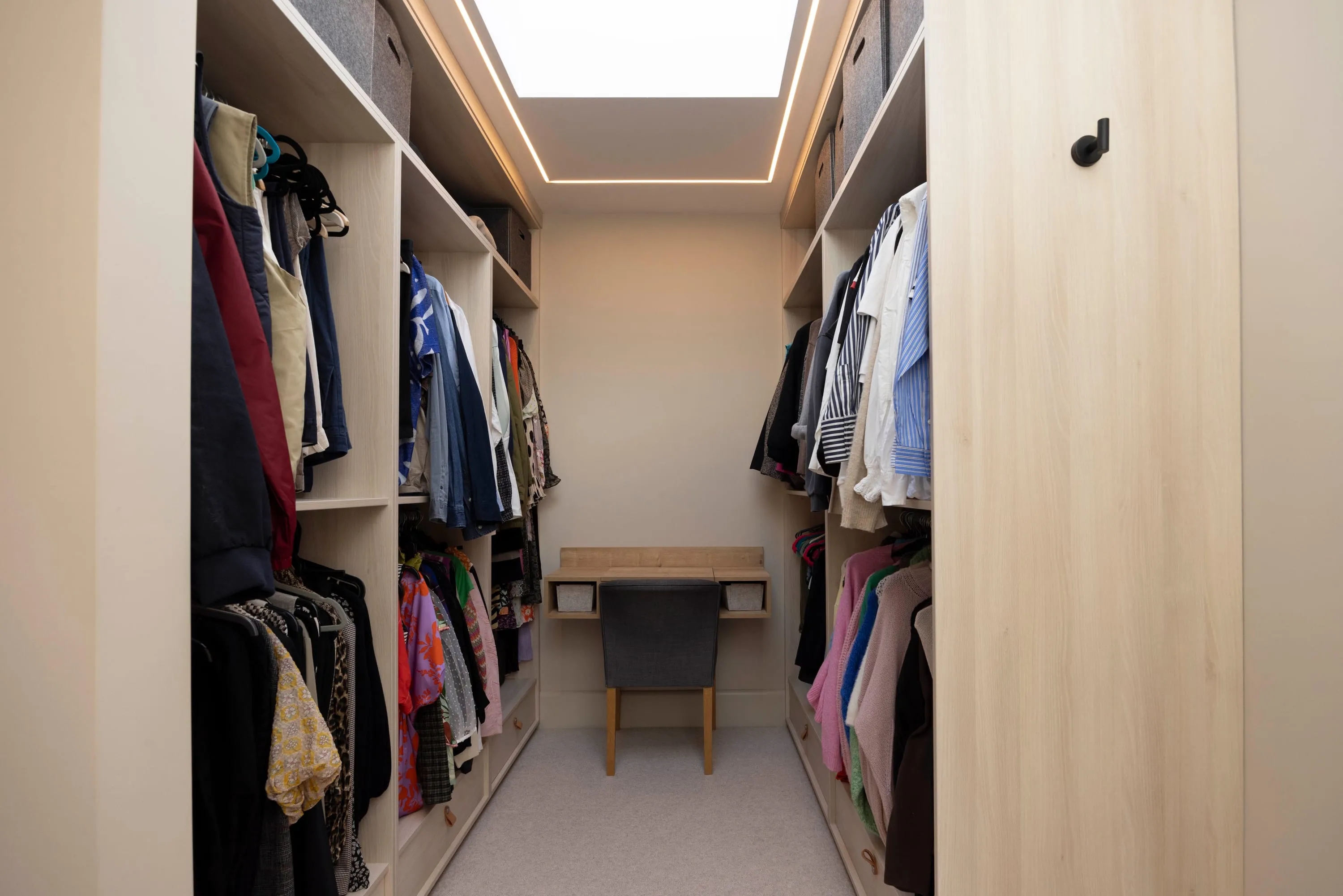 Walk-in dressing room with open wardrobes and skylight
