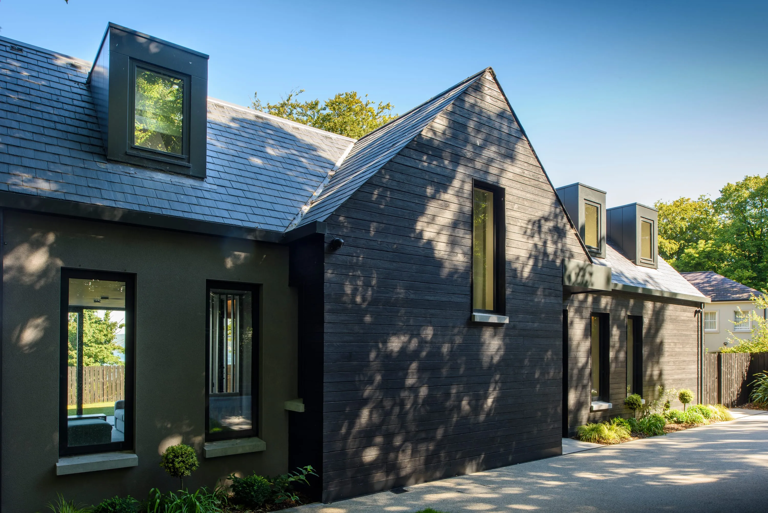 Front elevation in sunshine showing the slate roof and twin dormers