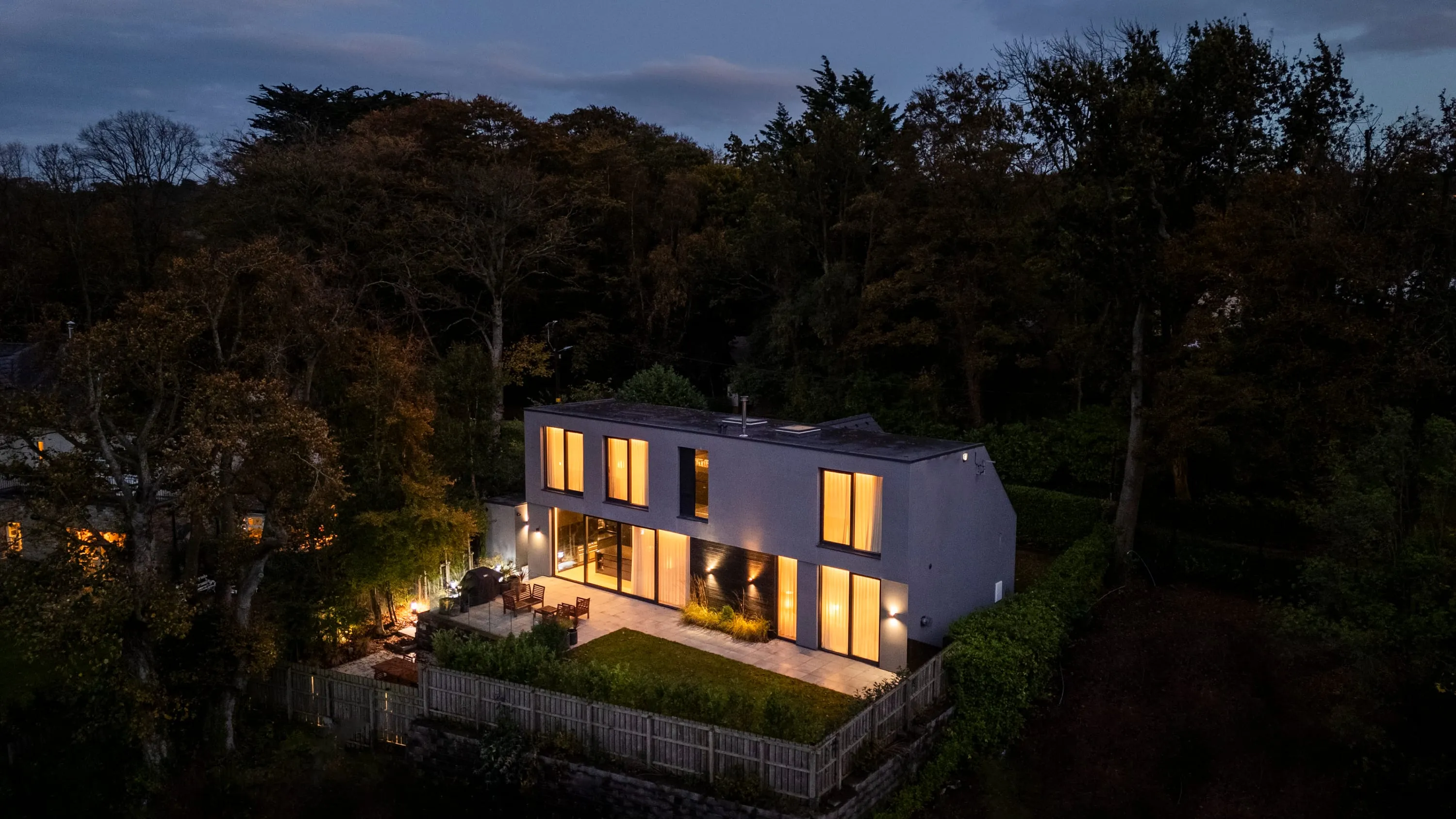 Aerial view at night of the house set among mature trees