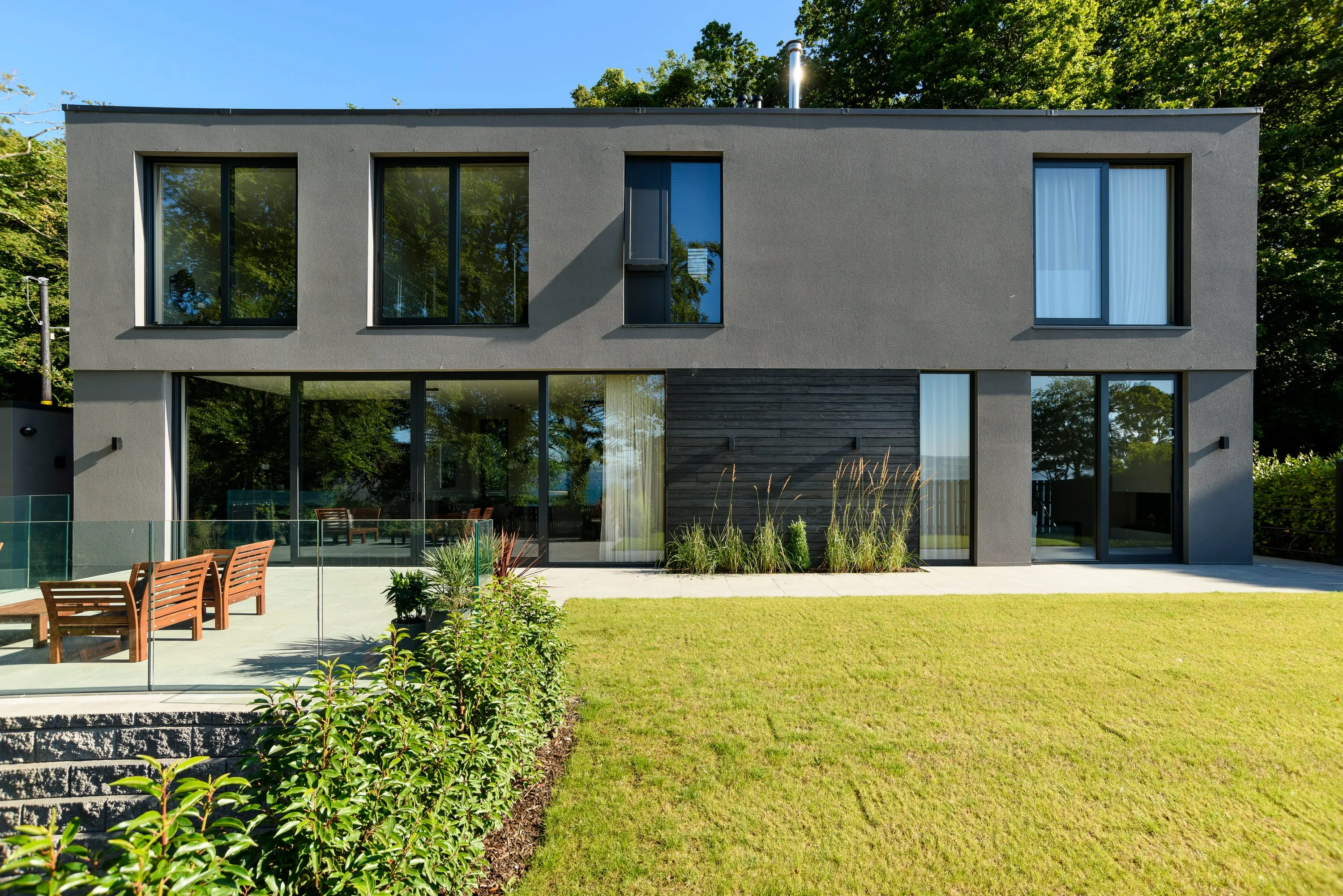 Rear of the house from the lawn, sliding glass doors open to the terrace