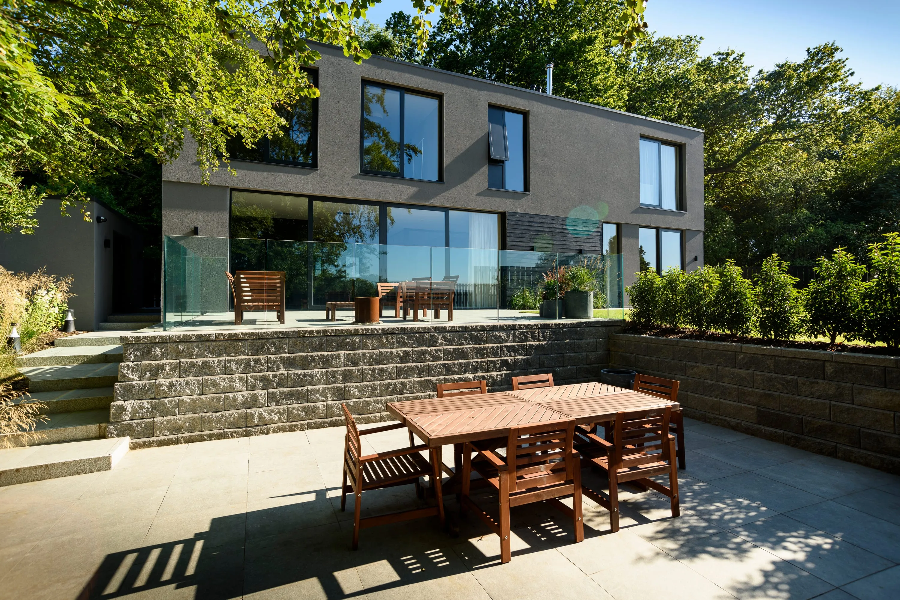 Terrace with stone retaining walls and dining furniture