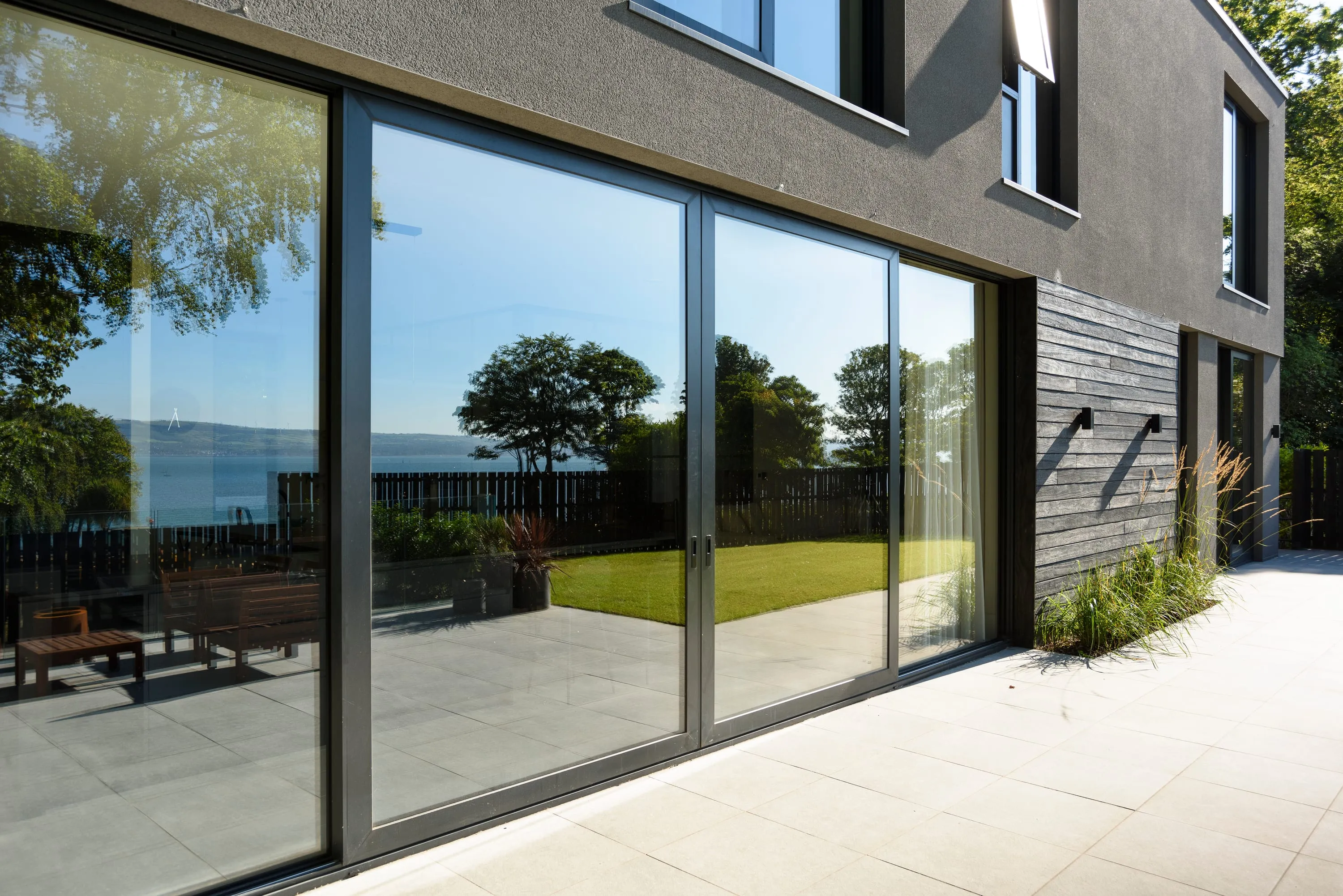 Sliding glass doors reflecting the lough and garden