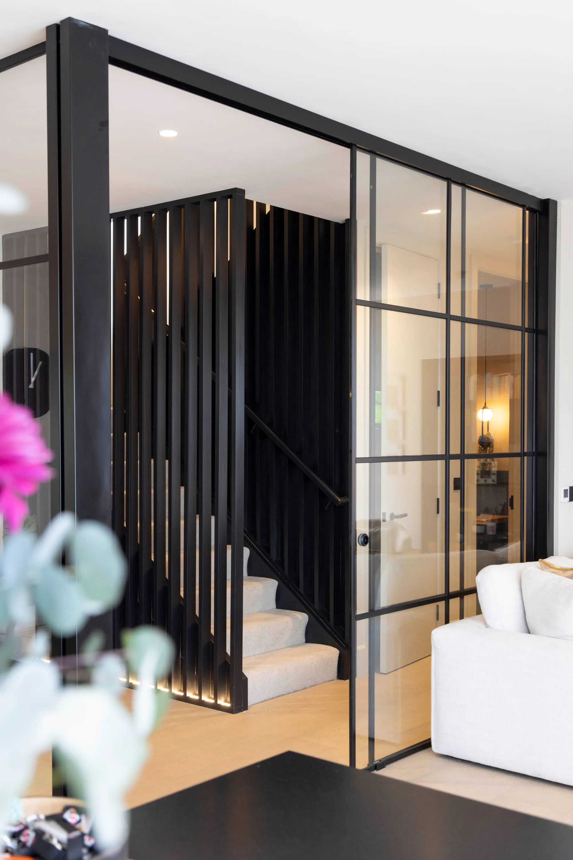Staircase behind the black-framed glazed screen