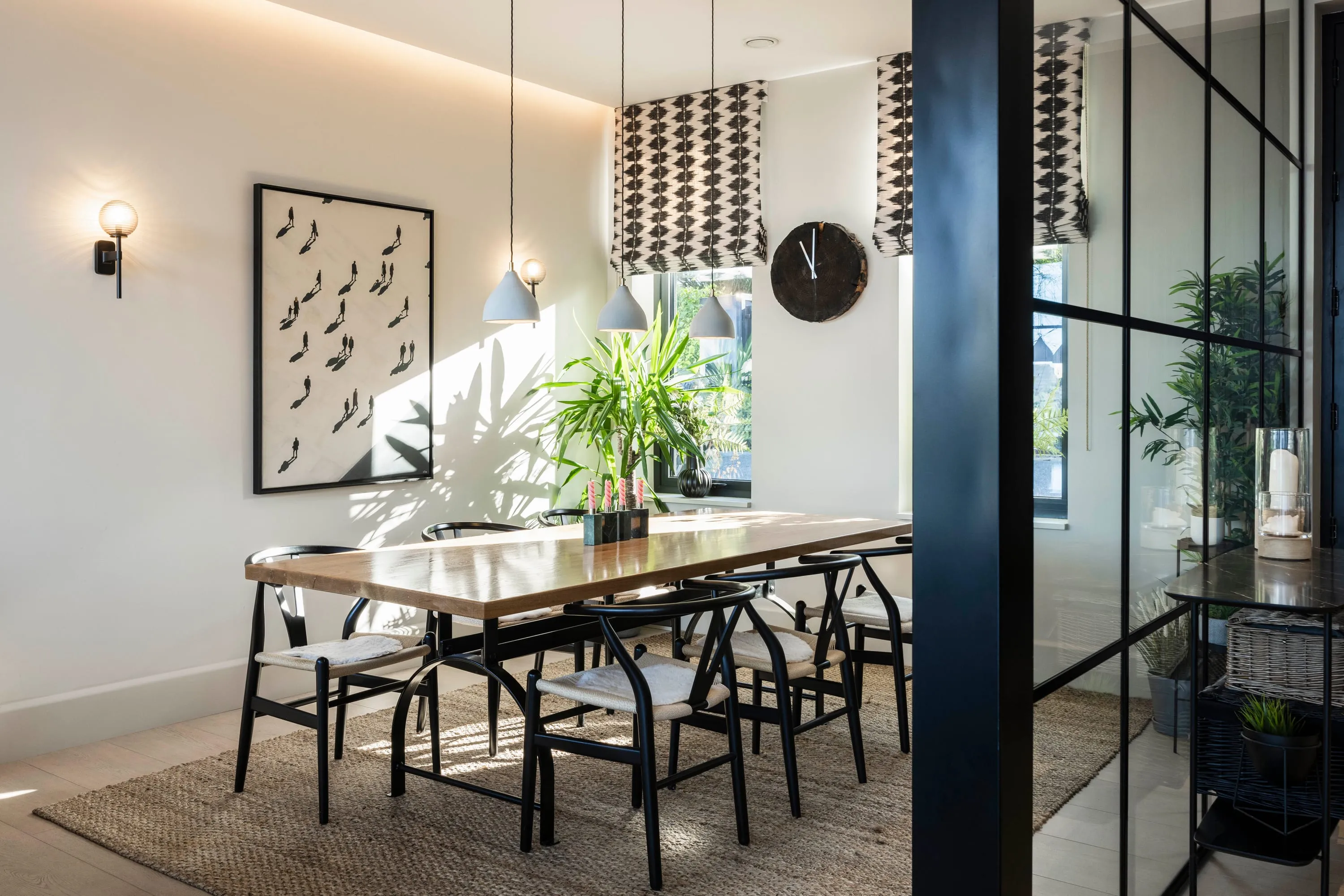 Dining table with Wishbone chairs beneath pendant lights