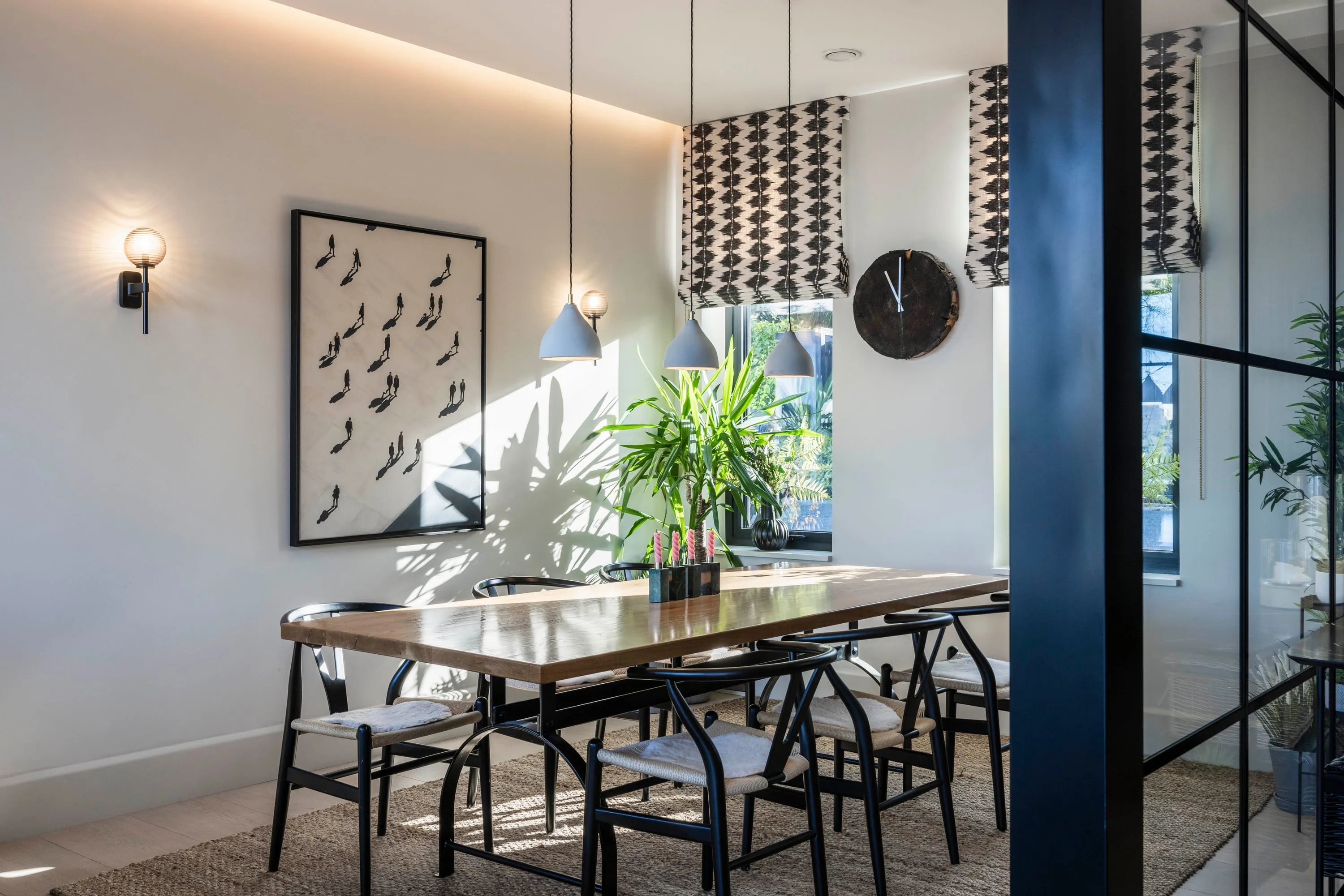 Oak dining table for eight with artwork and wall lights