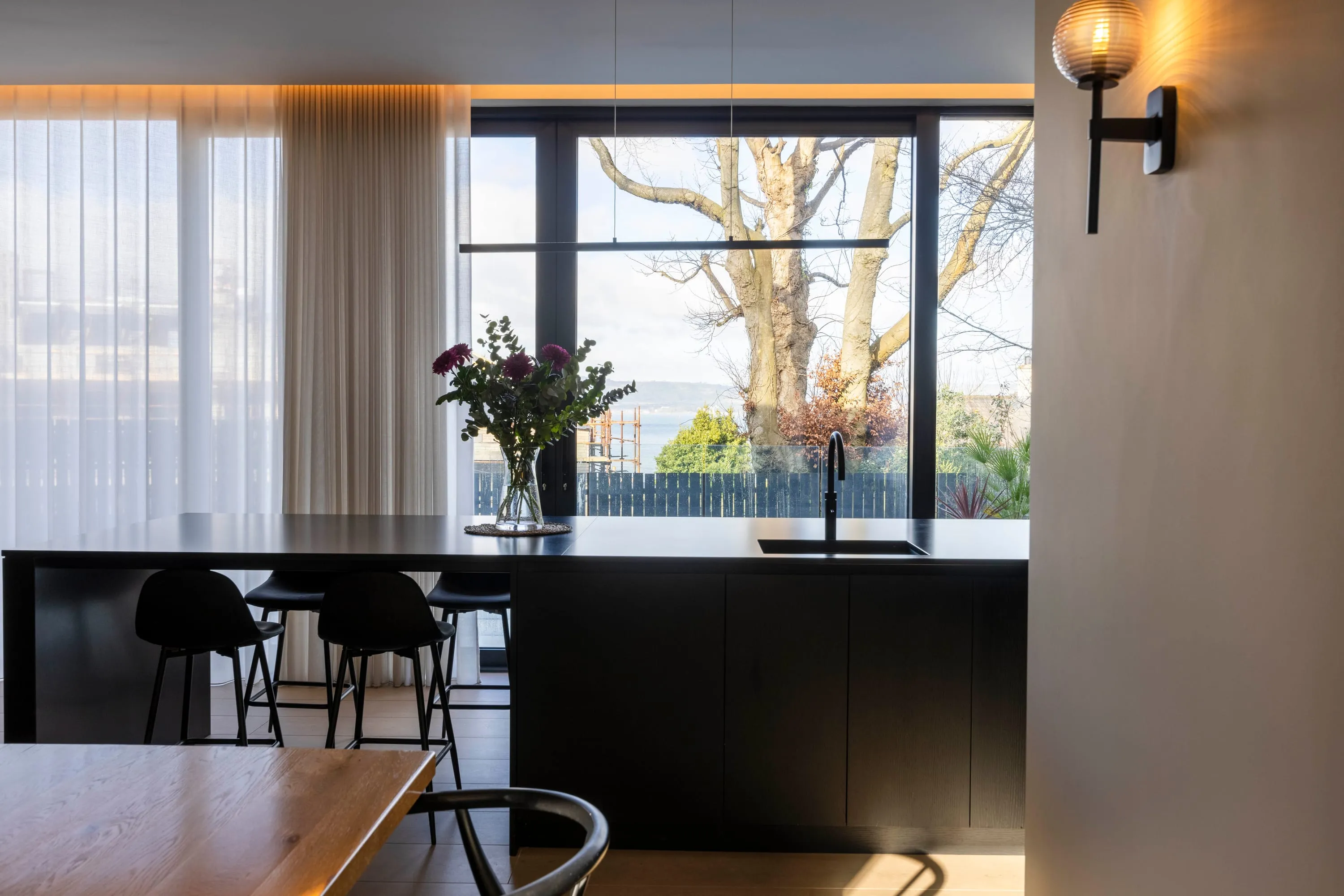 Black kitchen island and bar stools with the window view