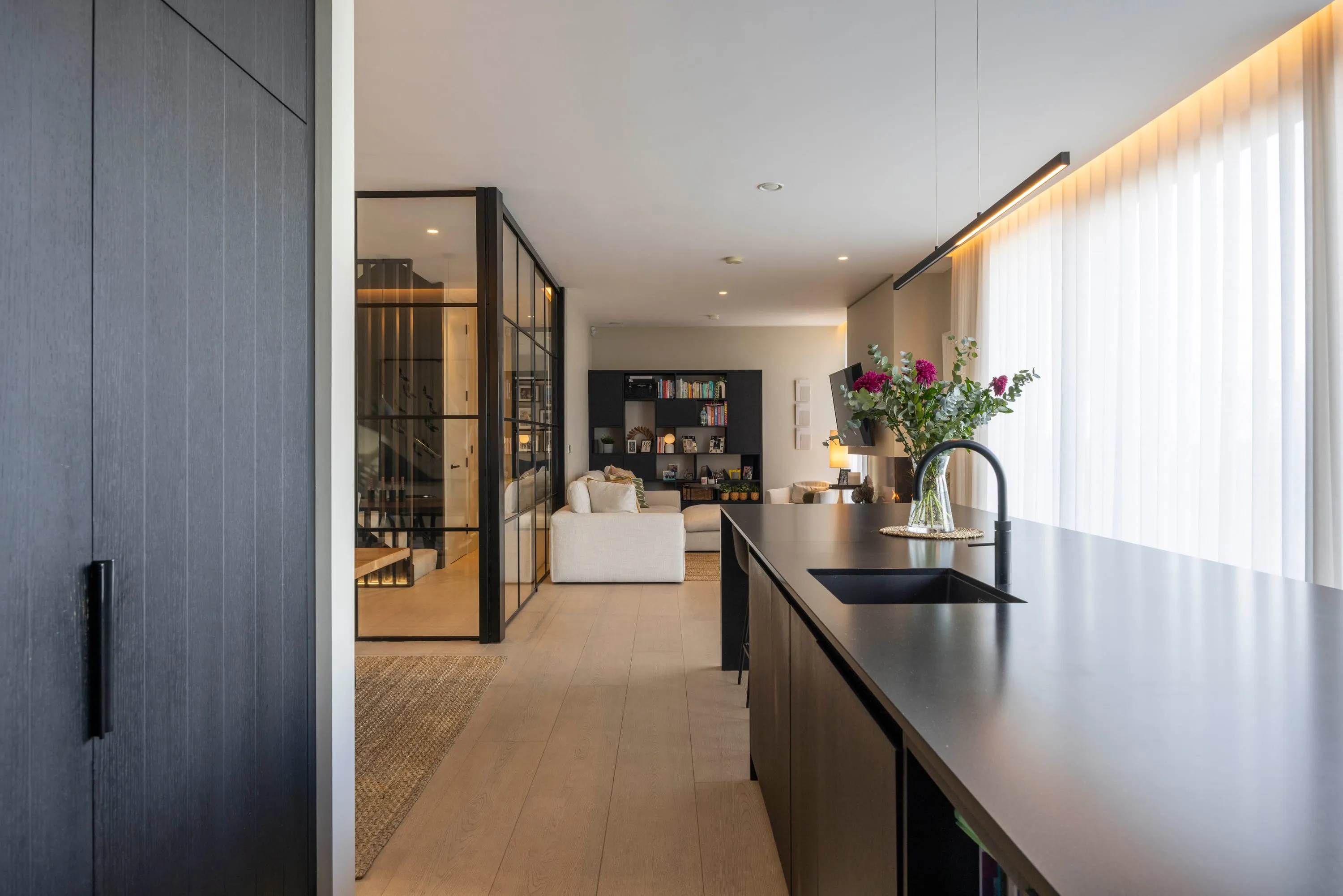 Long view along the kitchen island to the living area and fireplace