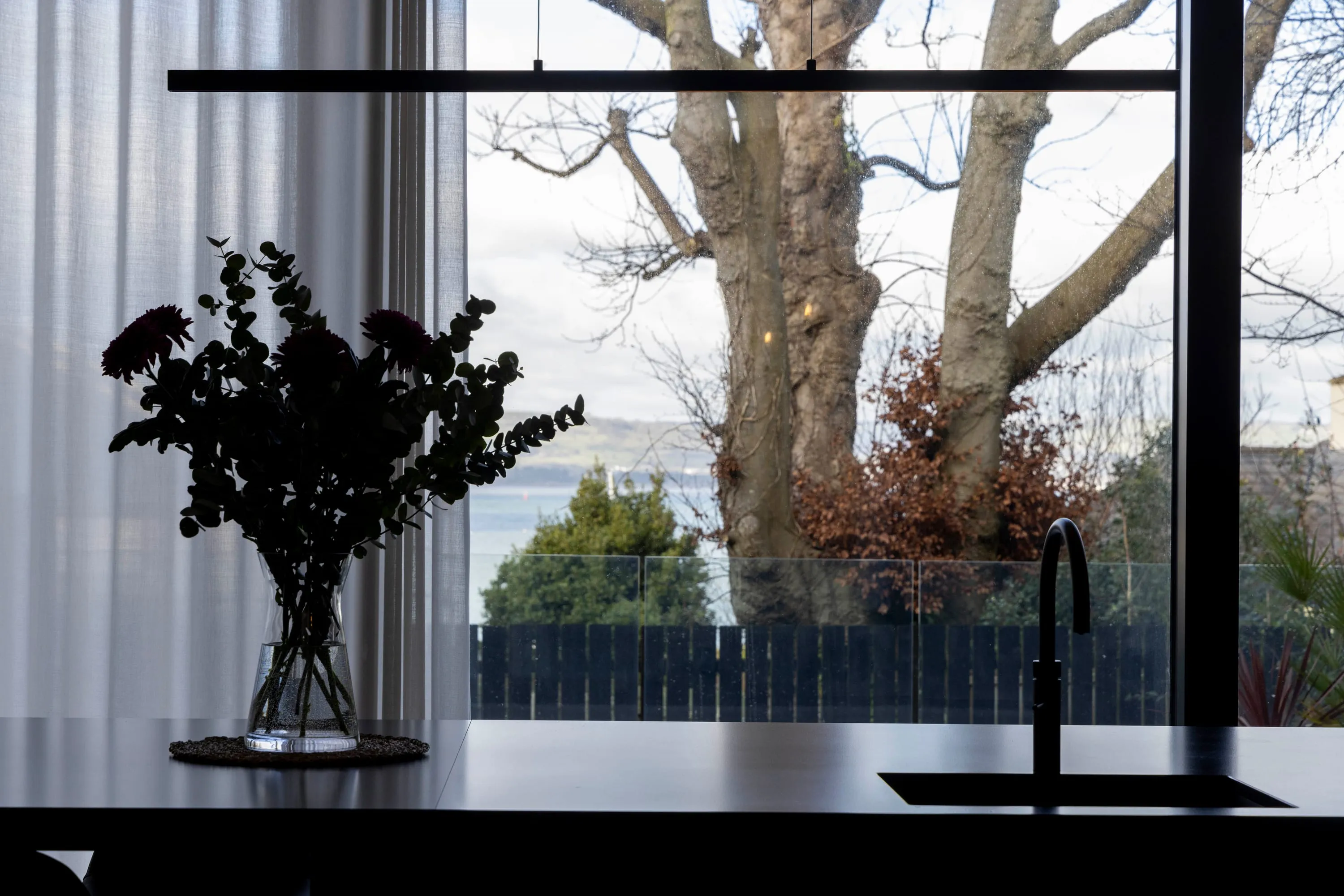 Kitchen window with flowers and the lough beyond