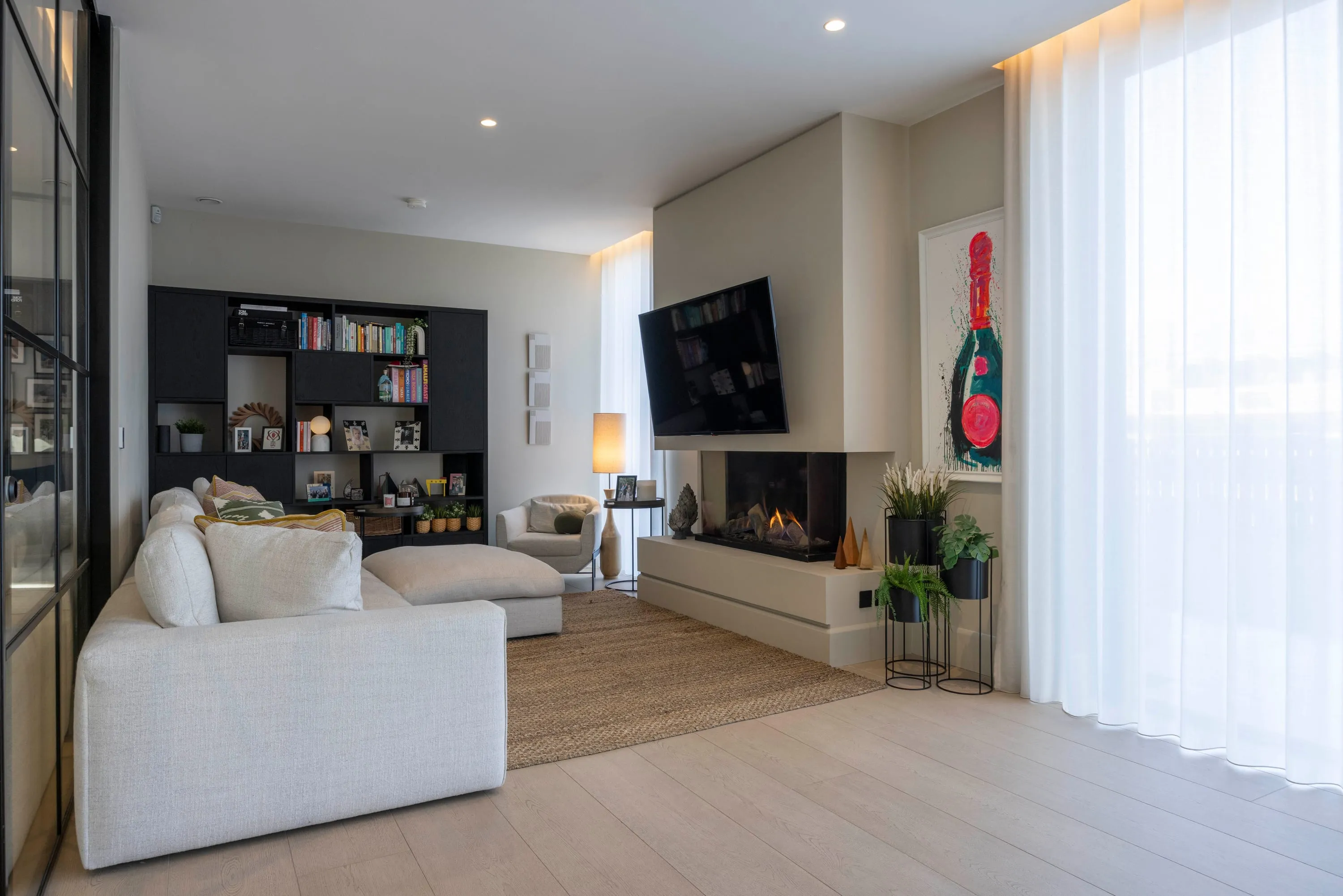 Living area with sofa, gas fire and built-in shelving