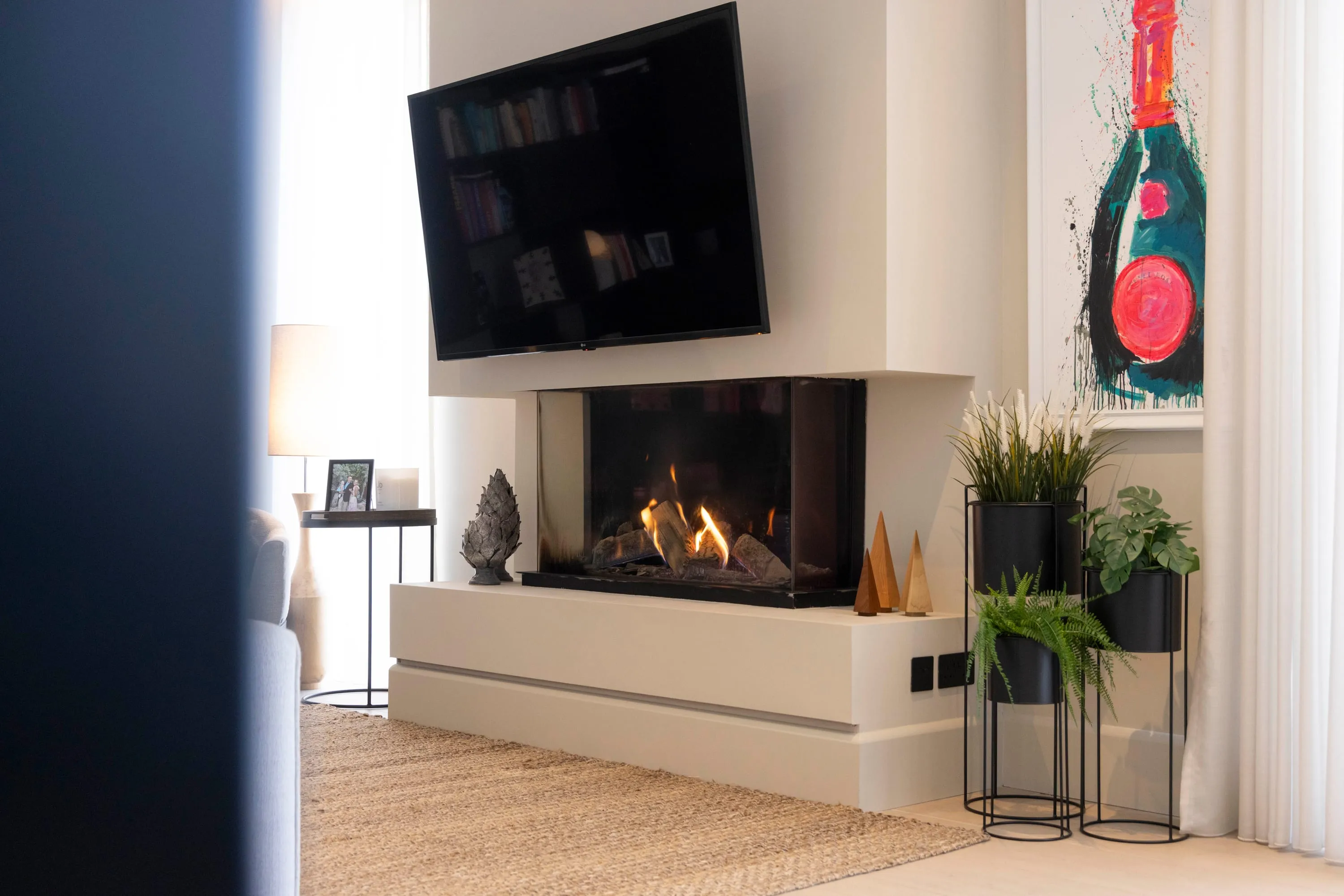 Fireplace with wall-mounted television and artwork