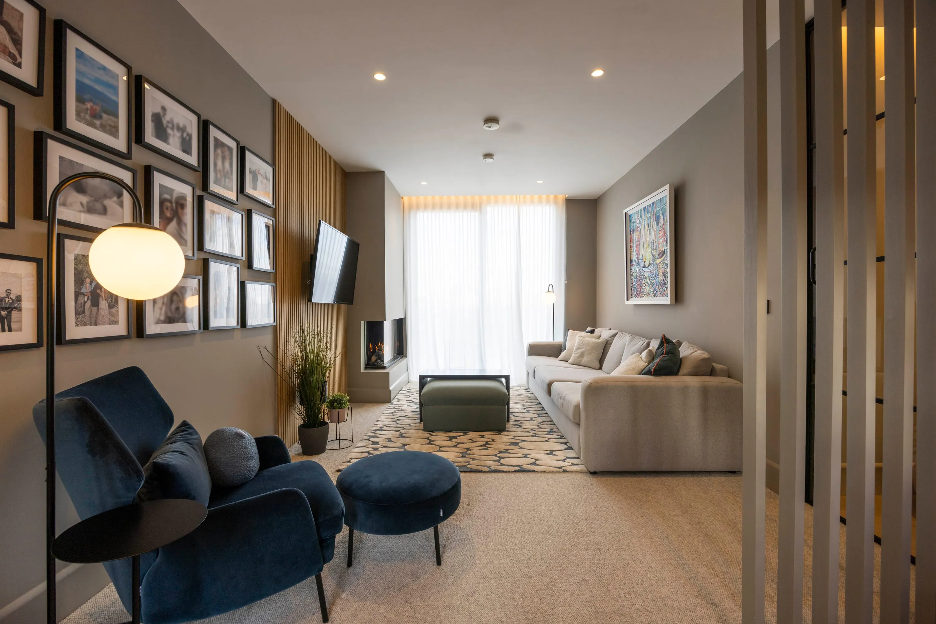Lounge with sofa, blue armchair and gallery wall