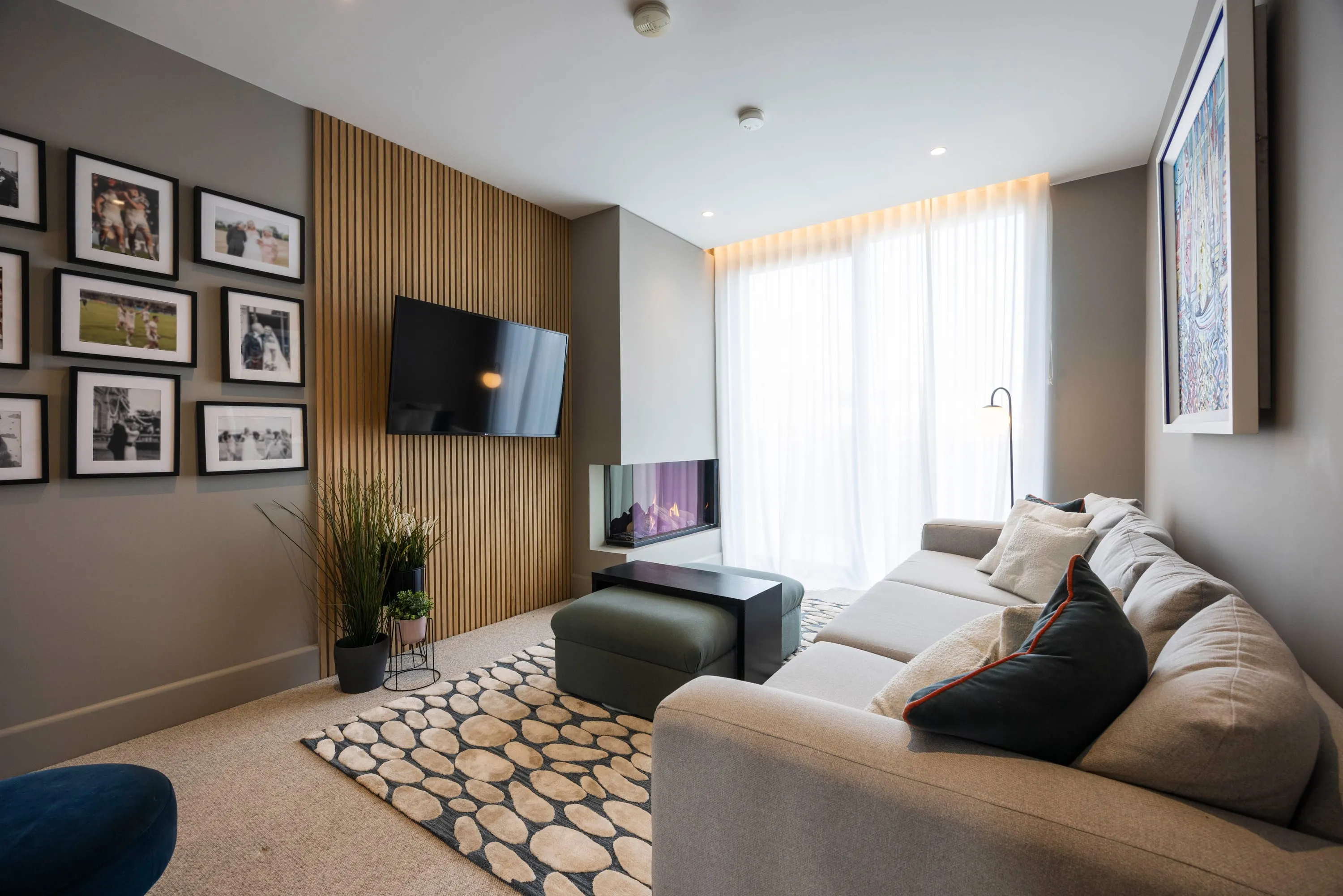 Lounge with wall-mounted television and slatted timber panel