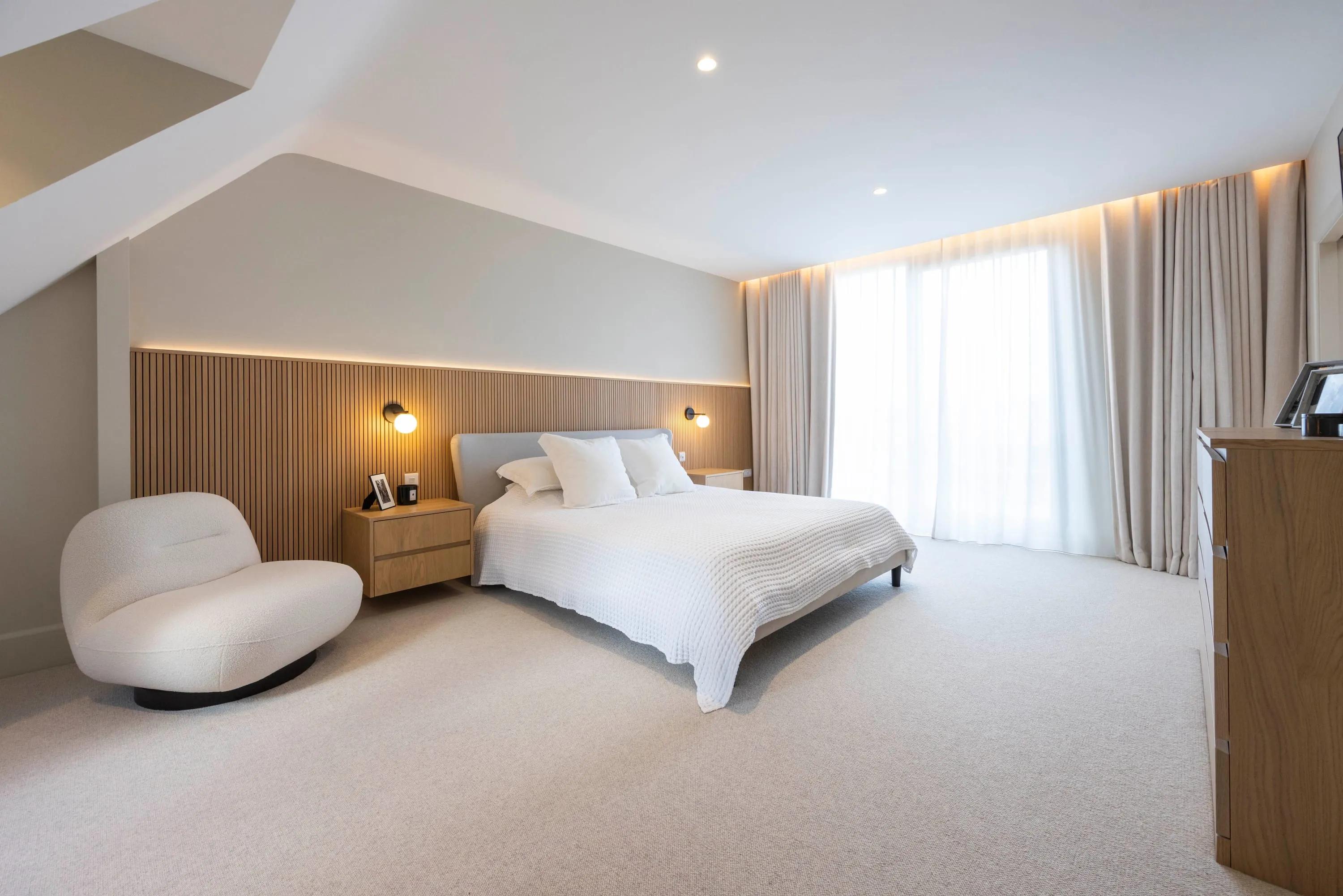 Principal bedroom with armchair and sheer curtains